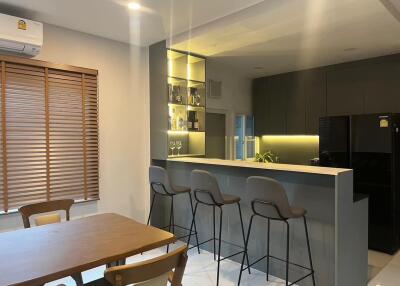 Modern kitchen with dining area, bar counter, and chairs