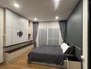 Spacious and modern bedroom with wooden flooring, built-in storage, and cozy lighting