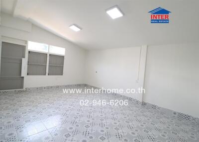 Spacious room with patterned floor tiles and large windows