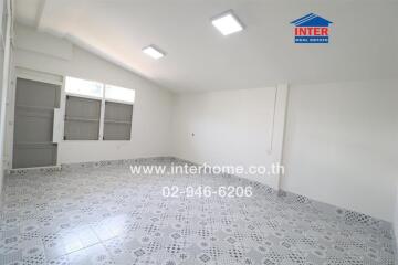 Spacious room with patterned floor tiles and large windows