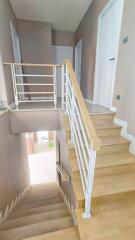 Modern staircase with wooden steps and white railing