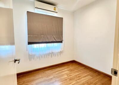 Empty bedroom with wooden floor and air conditioning