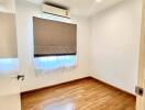 Empty bedroom with wooden floor and air conditioning