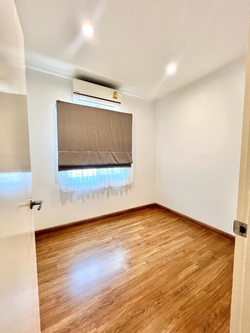 Empty bedroom with wooden floor and air conditioning