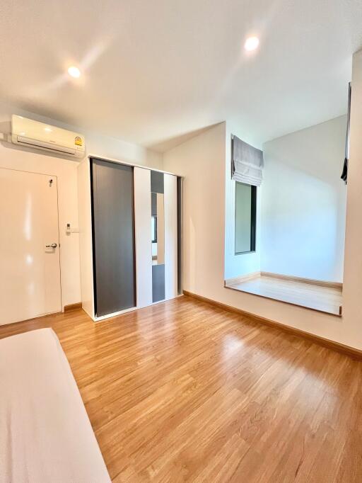 Modern and bright bedroom with wooden flooring and ample closet space