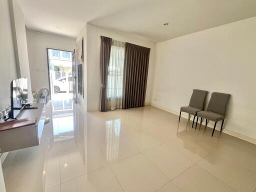 Spacious living room with tiled floor and minimal furnishings