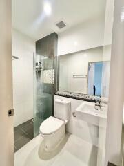 Modern bathroom with white fixtures and glass shower partition