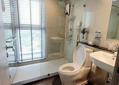 Modern bathroom with glass shower, toilet, sink, and vanity