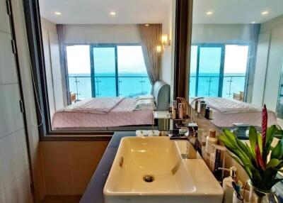 Bedroom with en suite bathroom featuring a sink and ocean view