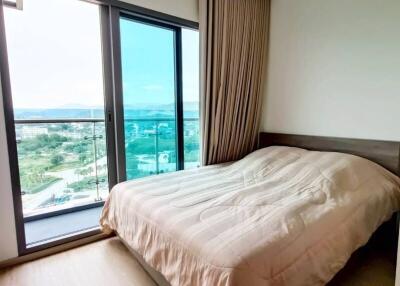 Cozy bedroom with a large window and balcony view