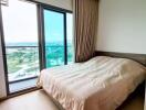 Cozy bedroom with a large window and balcony view