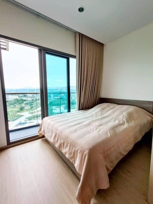 Cozy bedroom with a large window and balcony view