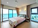 Modern bedroom with sea view, large windows, and double bed