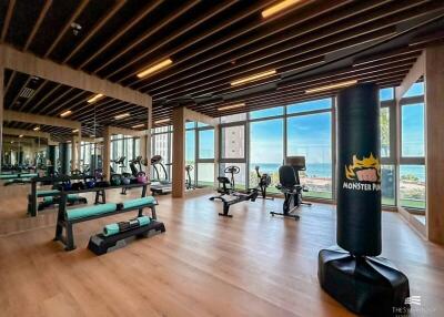 Modern gym with equipment and large windows with sea view