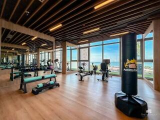 Modern gym with equipment and large windows with sea view