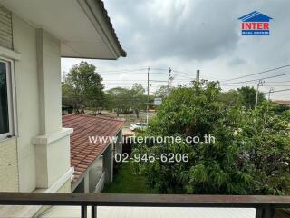 Balcony view with garden and neighboring buildings