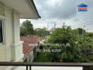 Balcony view with garden and neighboring buildings