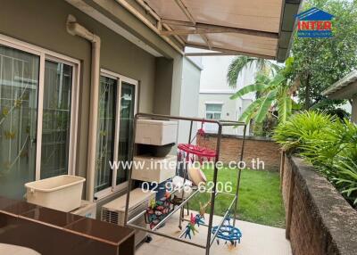 Outdoor patio area with laundry rack and garden view
