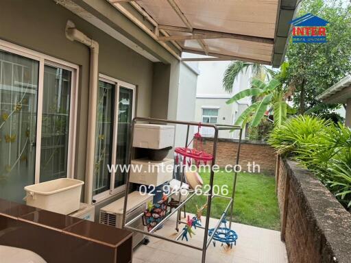 Outdoor patio area with laundry rack and garden view