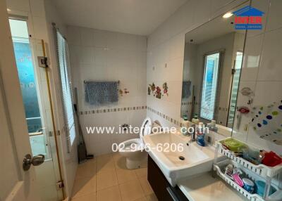 Bathroom with shower, sink, storage and decorative wall tiles
