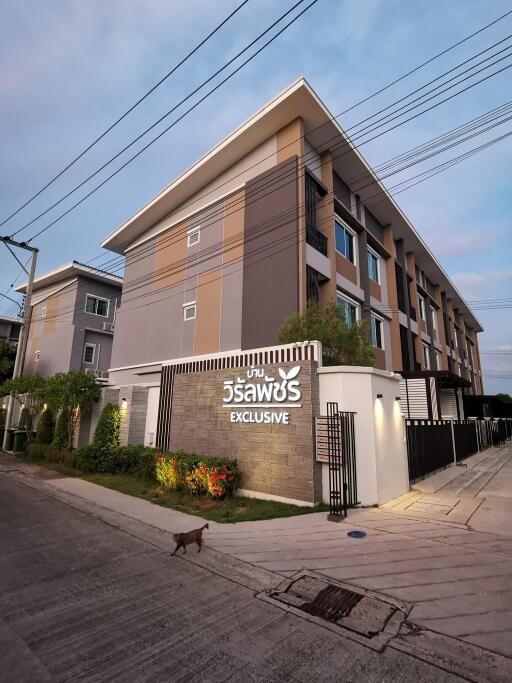 Exterior view of a residential building with multiple floors and a sign that reads 