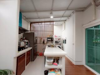 Modern kitchen with island, stainless steel appliances, and wooden accent wall