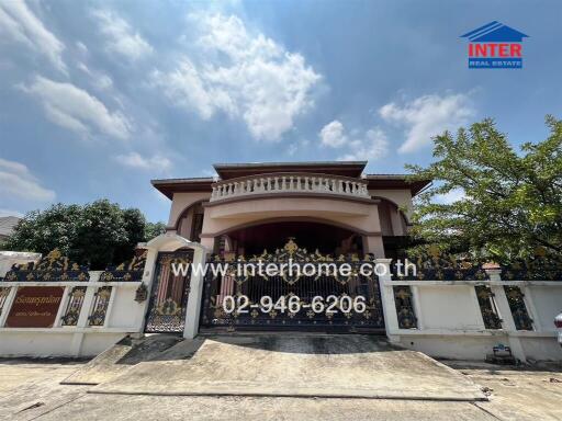 Outdoor view of a residential building with a decorative front gate and large balcony