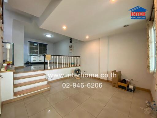 Spacious living room with balcony view and tiled flooring