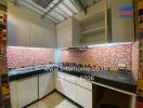 Modern kitchen with colorful mosaic tile backsplash.