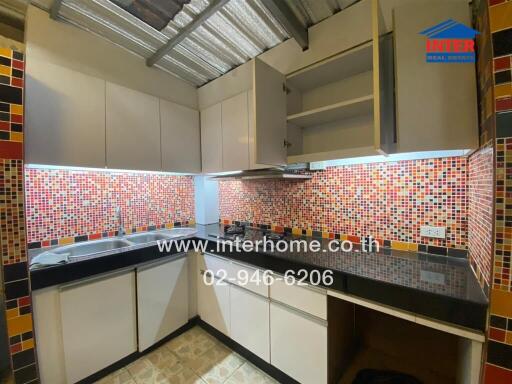 Modern kitchen with colorful mosaic tile backsplash.