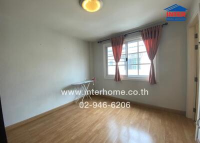 Empty bedroom with wooden floor and large window