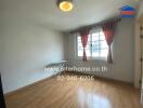 Empty bedroom with wooden floor and large window