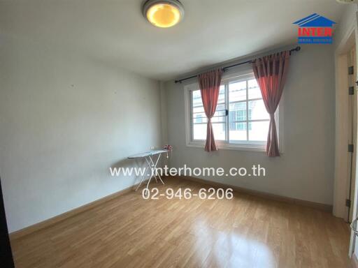 Empty bedroom with wooden floor and large window