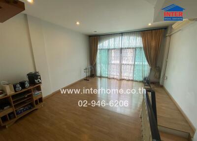 Spacious main living area with wooden flooring and large windows