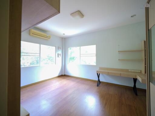 Spacious bedroom with hardwood floors and ample natural light