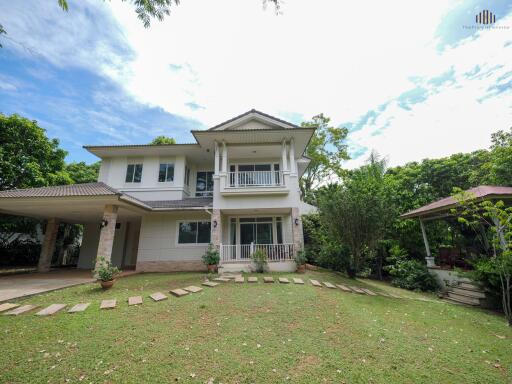 A two-story house with a front yard and a covered carport.