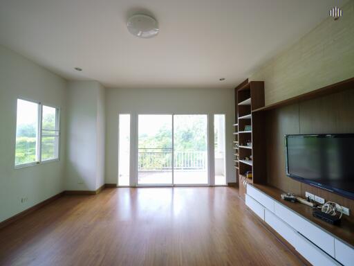 spacious living room with large windows and built-in shelves