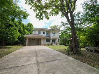 Two-story house with driveway and surrounding trees