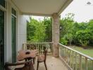 Balcony with wooden furniture and view of garden