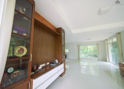 Spacious living room with large windows and built-in wooden cabinetry