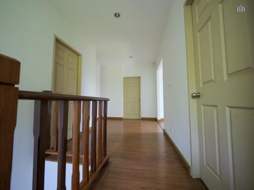 Spacious hallway with wooden floor and multiple doors