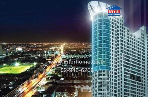 Night view of a modern high-rise building along a brightly lit cityscape.