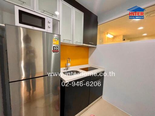 Modern kitchen with stainless steel refrigerator and built-in cabinets
