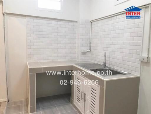 Modern kitchen with white subway tile backsplash and compact sink area