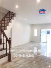 Spacious living room with a staircase and ample natural light