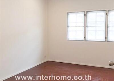 Bedroom with hardwood flooring and multiple windows