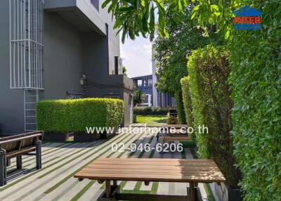 Outdoor area with greenery and bench seating