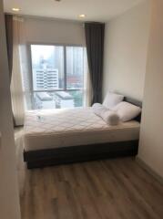 Modern bedroom with a large window and city view