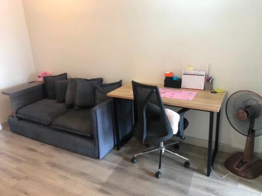 Bedroom with study area featuring a sofa, desk, chair, and fan