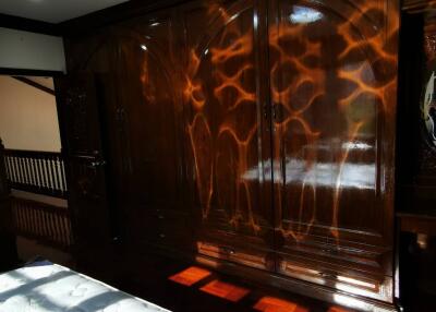 Bedroom with large wooden wardrobe and bed